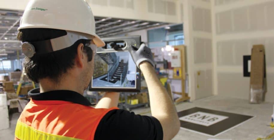 Worker using tablet with Augmented Reality in a site