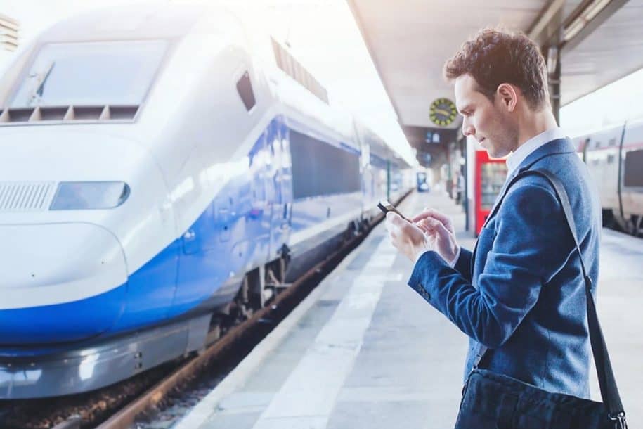Man using smartphone in a train station